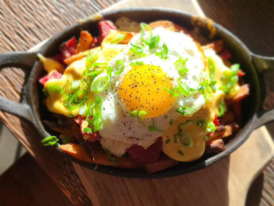 Poutine in a cast iron dish with egg