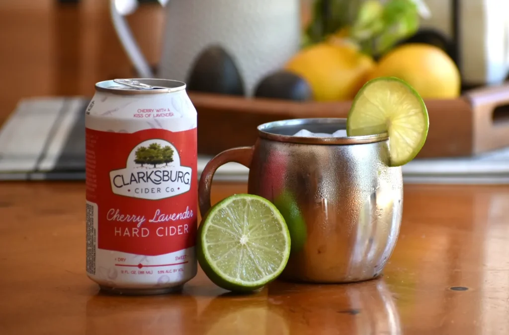 Cherry Lavender Mule cocktail next to a can of Clarksburg Cherry Lavender hard cider.